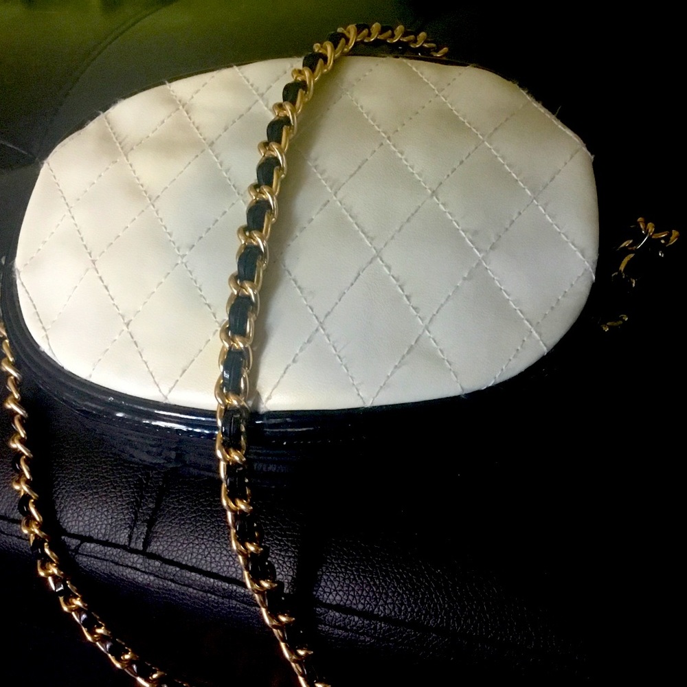 White and black quilted shoulder bag with faux pearl and bone necklace.  18”drop